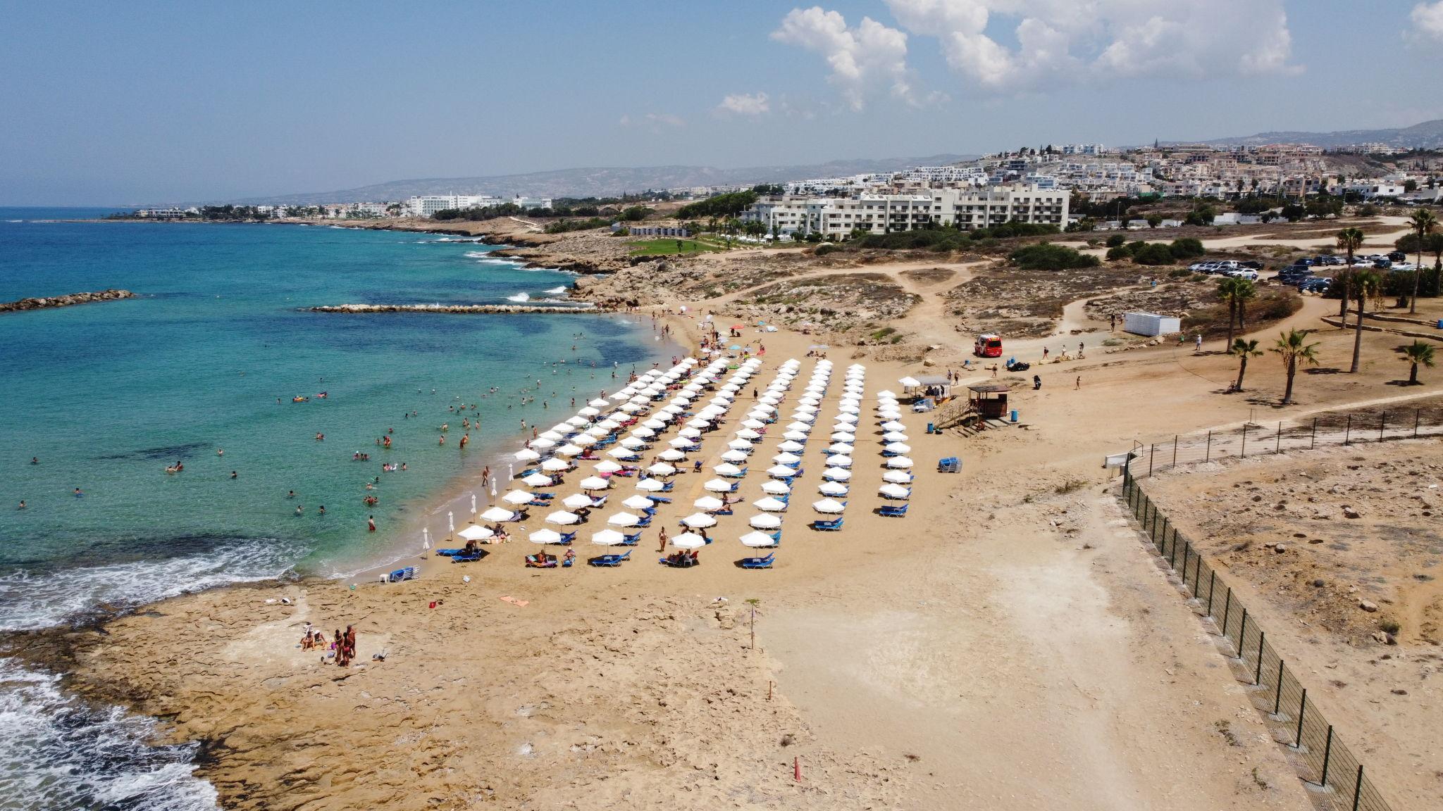 Venus Beach in Paphos, Cyprus, with golden sand, clear Mediterranean water and the coastline near the Tombs of the Kings.